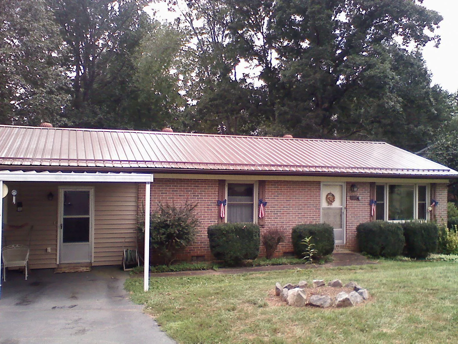 Bronze metal roof and carport on a brick ranch home — Roof Repair work by our crew in Humboldt
